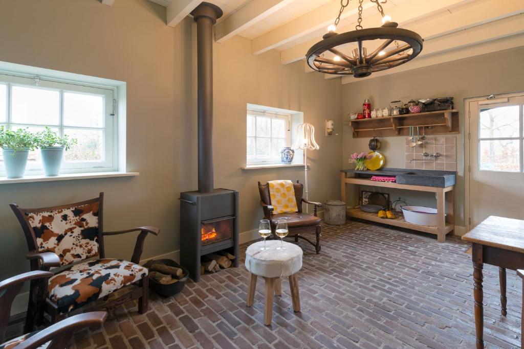 ein Wohnzimmer mit einem Holzofen und Stühlen in der Unterkunft B&B De Ouw Skuur in Oirschot