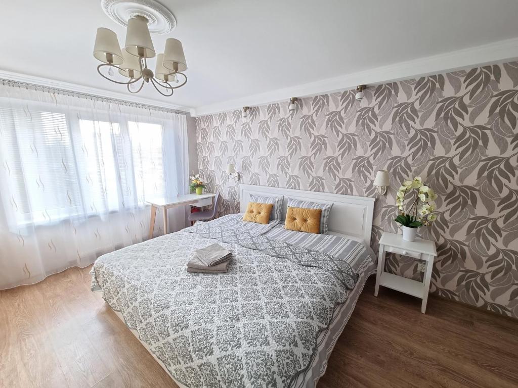 um quarto com uma cama com uma colcha cinzenta e branca em Kraslava 2 Bedroom Lux Apartments em Kraslava