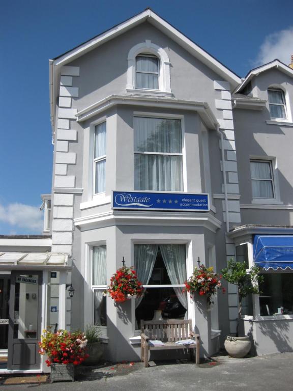 a white building with a bench in front of it at The Westgate in Torquay
