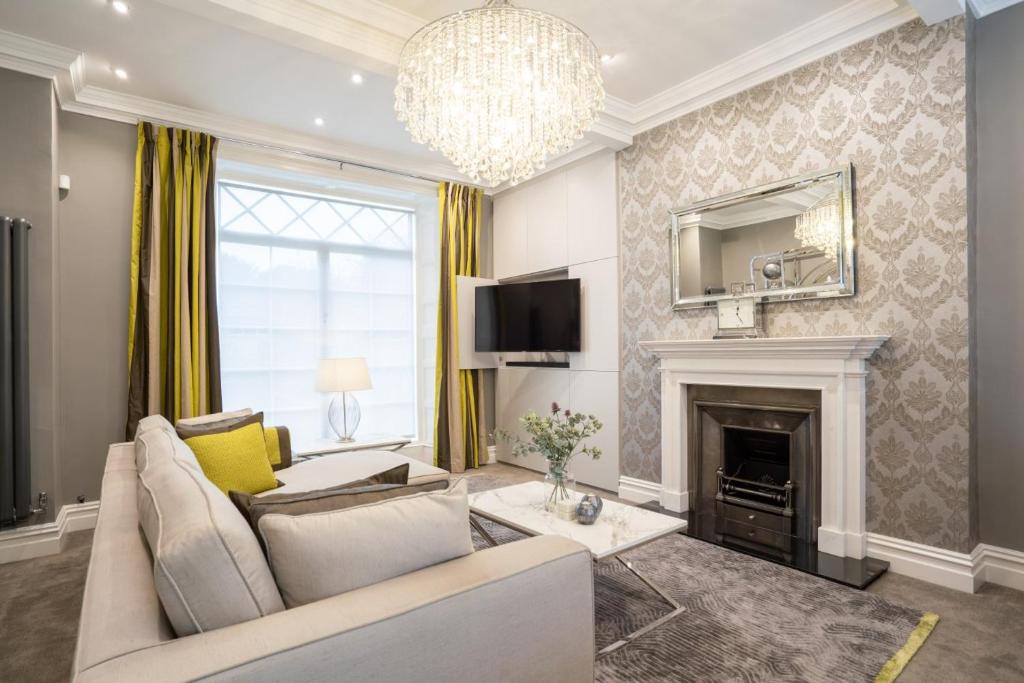 uma sala de estar com um sofá e uma lareira em Wellington Square - By Luxury Apartments em Cheltenham