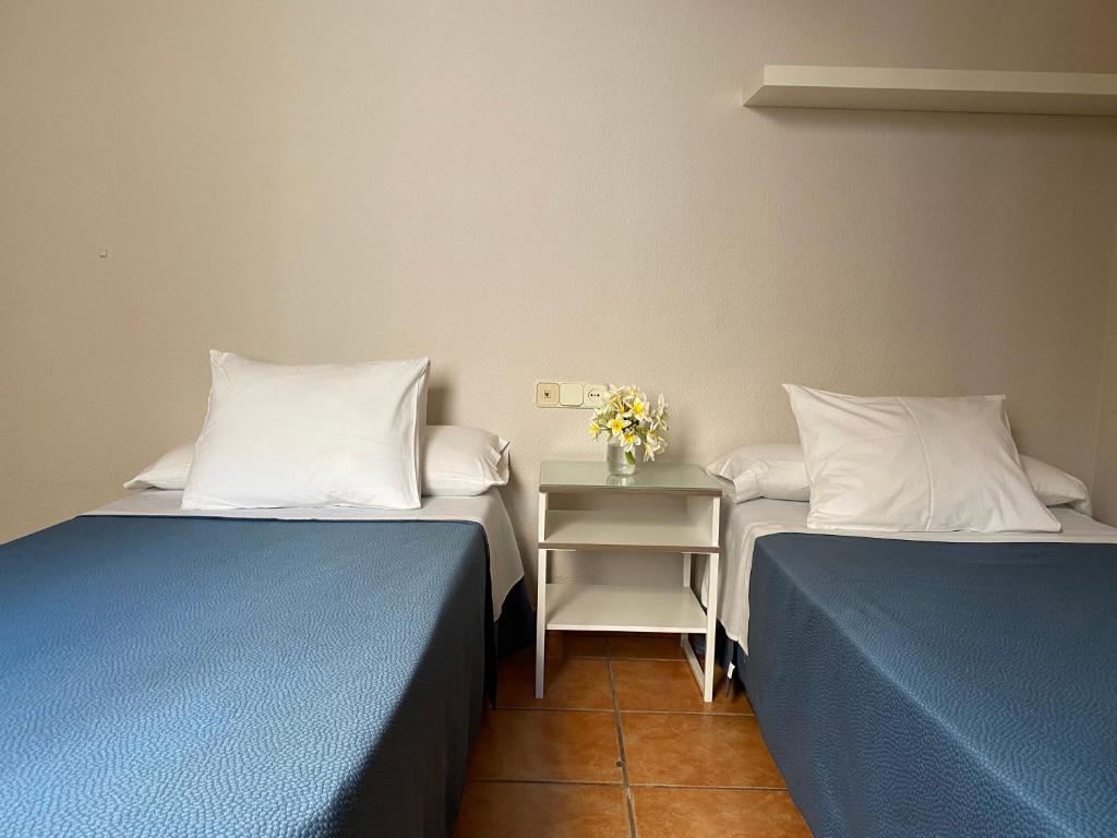 A bed or beds in a room at Hostal Moscatel