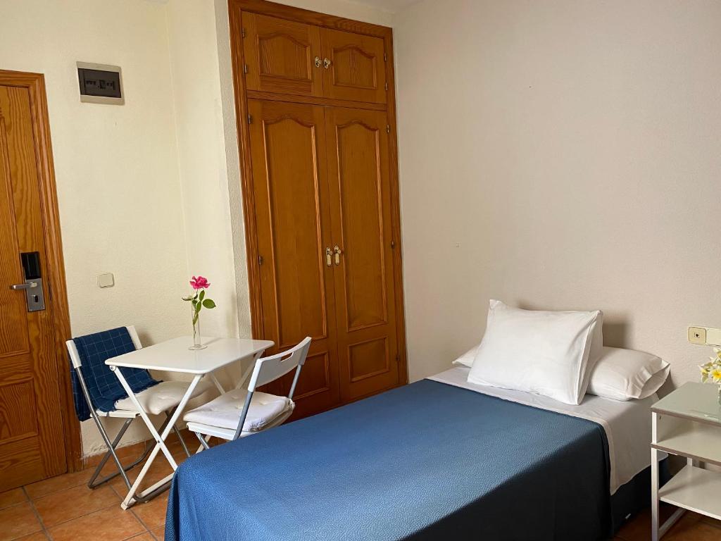 A bed or beds in a room at Hostal Moscatel