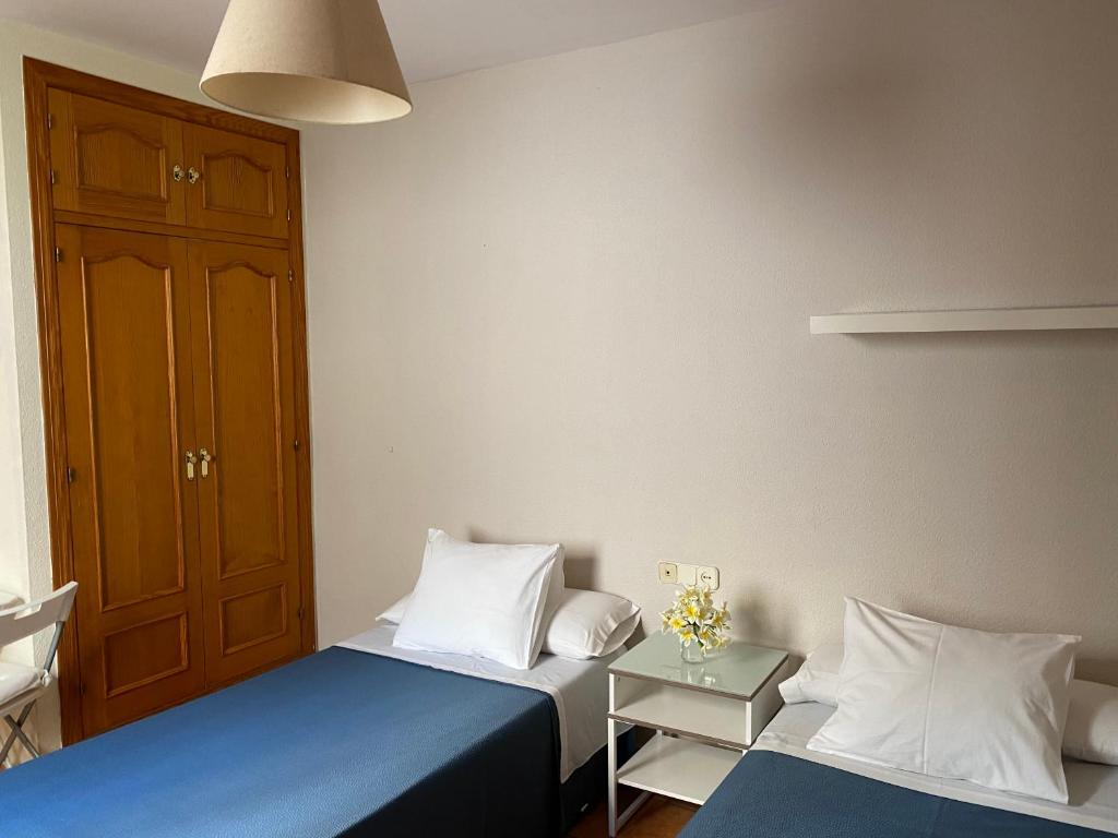 A bed or beds in a room at Hostal Moscatel