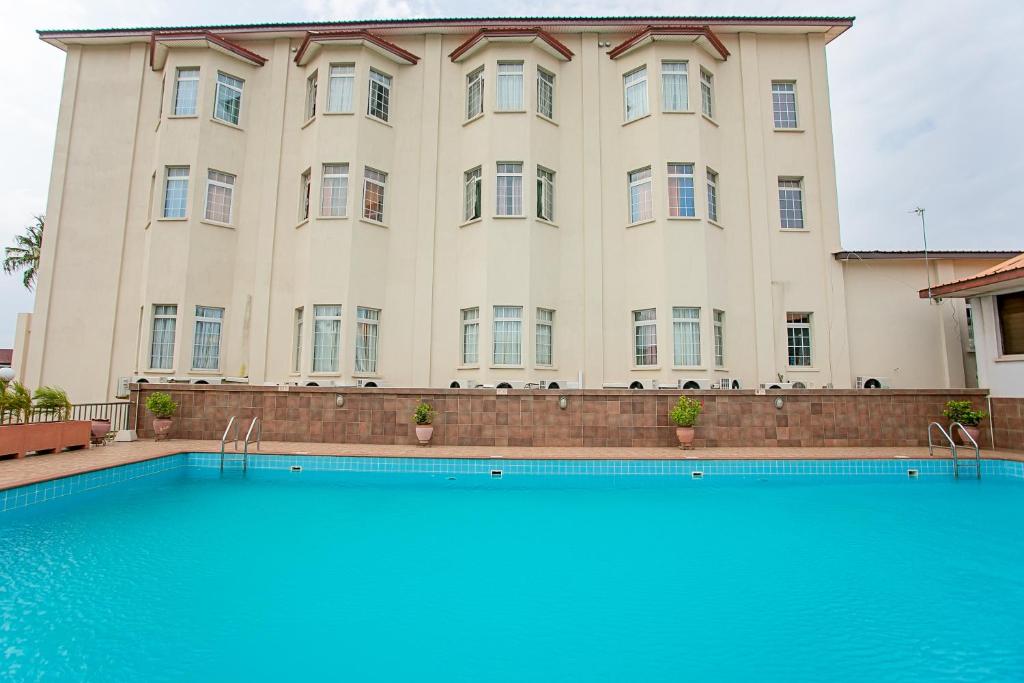 un gran edificio con una piscina frente a él en The Congress Hotel, en Accra