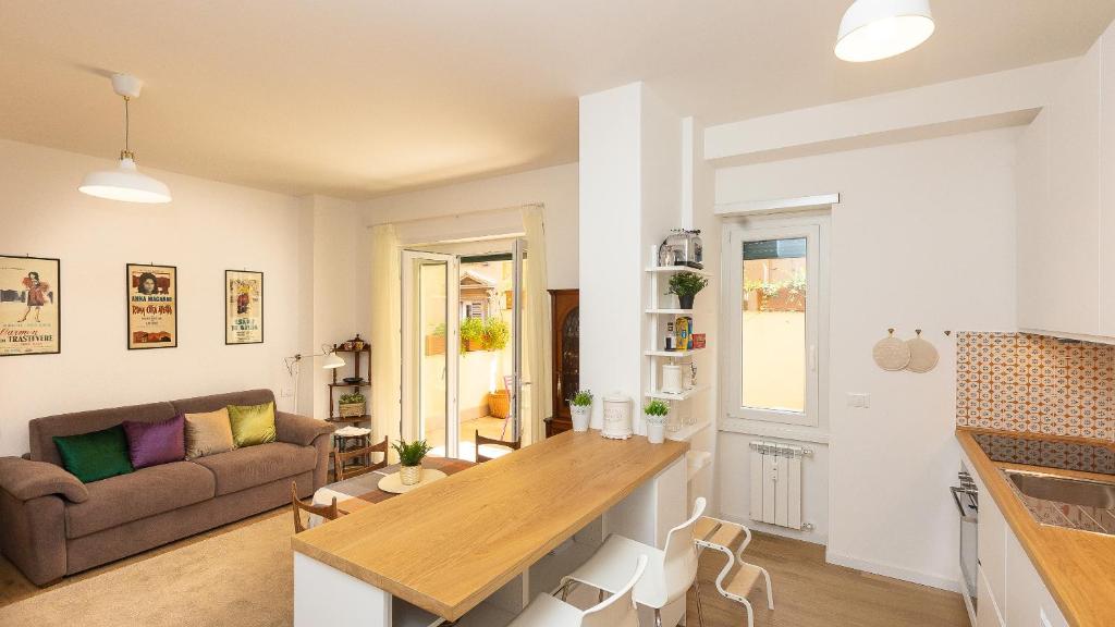 Il comprend une cuisine et un salon avec une table et un canapé. dans l'établissement Rental in Rome - Annietta, à Rome