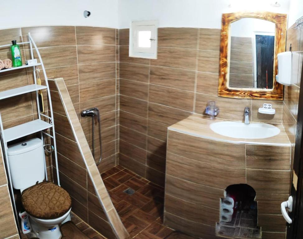 a bathroom with a sink and a toilet and a mirror at Casa Mona in Merzouga