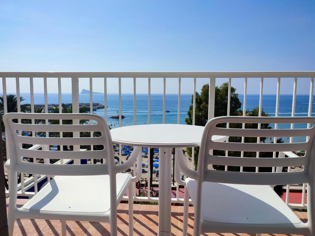 - un balcon avec deux chaises et une table donnant sur l'océan dans l'établissement Hotel Flats Friends Mar Blau, à Benidorm