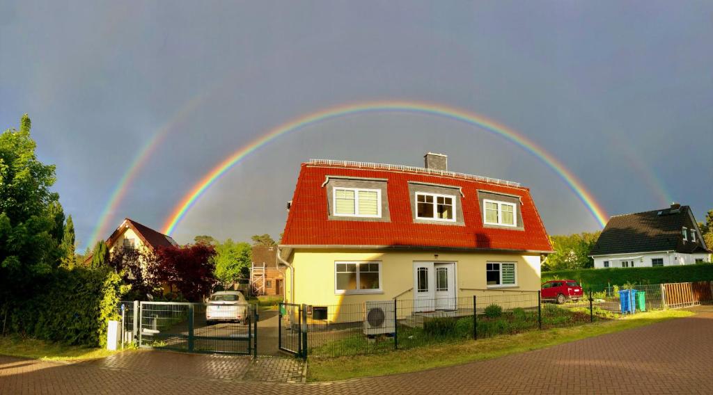 a rainbow in the sky above a house at Apartment im OG zwischen See und Wald mit großem Garten in Bestensee