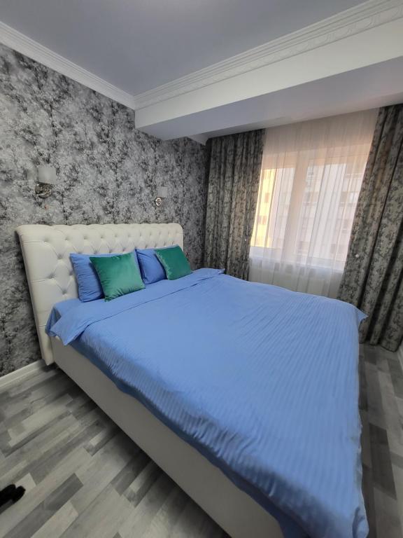 Vip apartment for lovers in Chisinau في كيشيناو: غرفة نوم مع سرير ووسائد زرقاء وأخضر