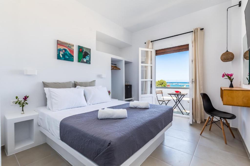 a bedroom with a bed with a view of the ocean at Uncle John's Guesthouse in Skopelos Town