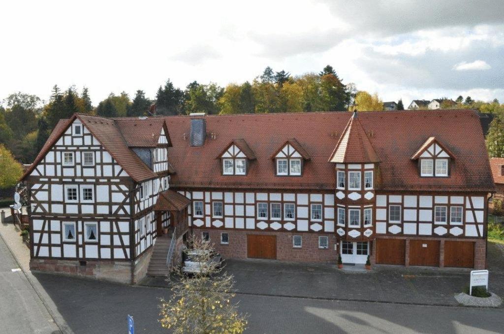 a large building with white and brown at Hotel Zum Stern in Rauischholzhausen