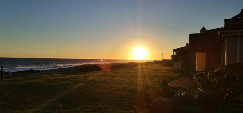 una puesta de sol en una playa con el océano en Hermanus Beach Club - Le Maree House 18, en Hermanus