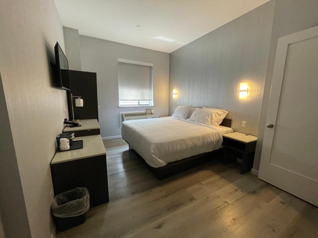 une chambre d'hôtel avec un lit et une télévision dans l'établissement King Hotel Brooklyn Sunset Park, à Brooklyn