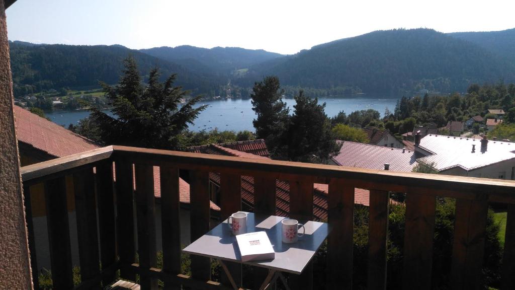 - une table sur un balcon avec vue sur le lac dans l'établissement Appartement balcon Vue lac, à Gérardmer