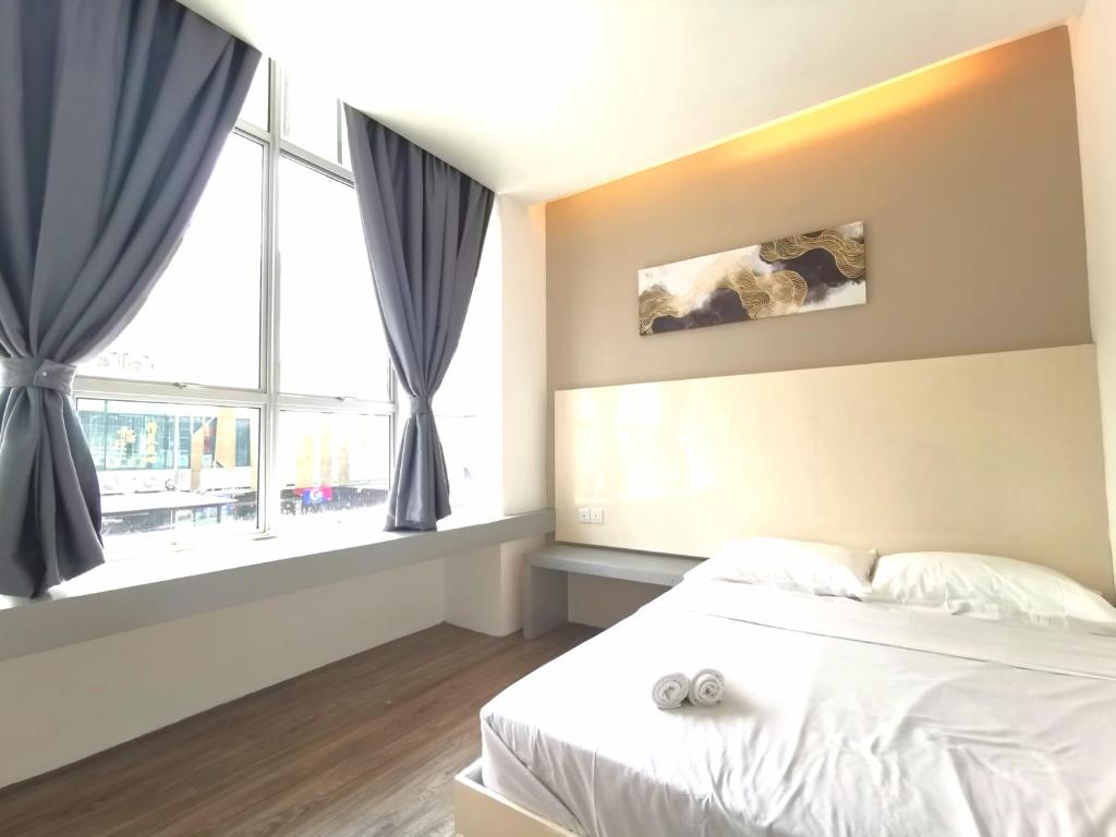 um quarto com uma cama e uma grande janela em Maco Inn Austin Heights @Johor Bahru em Johor Bahru