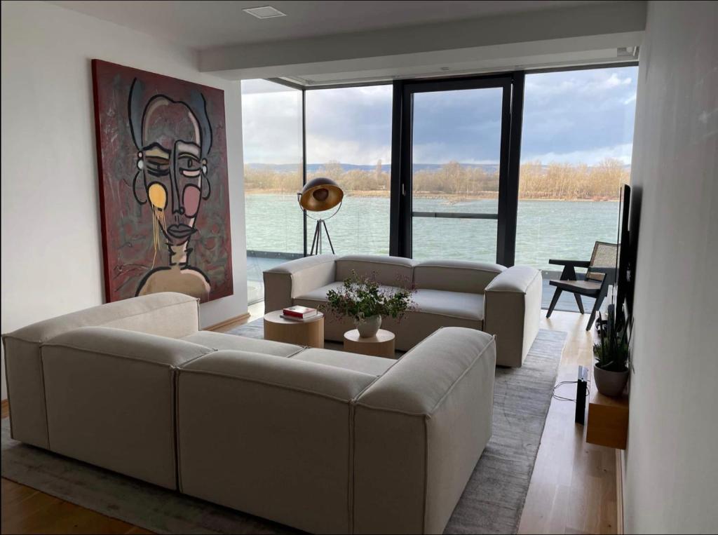 uma sala de estar com sofás e uma pintura na parede em Modernes Apartment mit wunderschonem Rheinblick em Urmitz