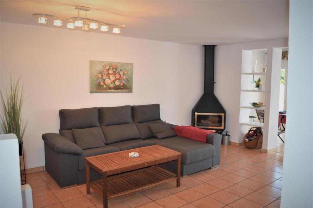a living room with a couch and a table and a fireplace at Urbanisation Les Basetes in Denia