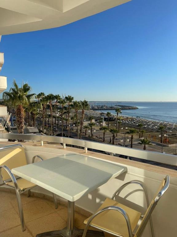 a table and chairs on a balcony with a view of the beach at Alex Beach Apartment 34 in Larnaca