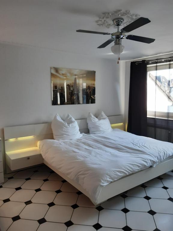 a bed in a room with a ceiling fan at Oldtown City Apartments Düsseldorf in Düsseldorf