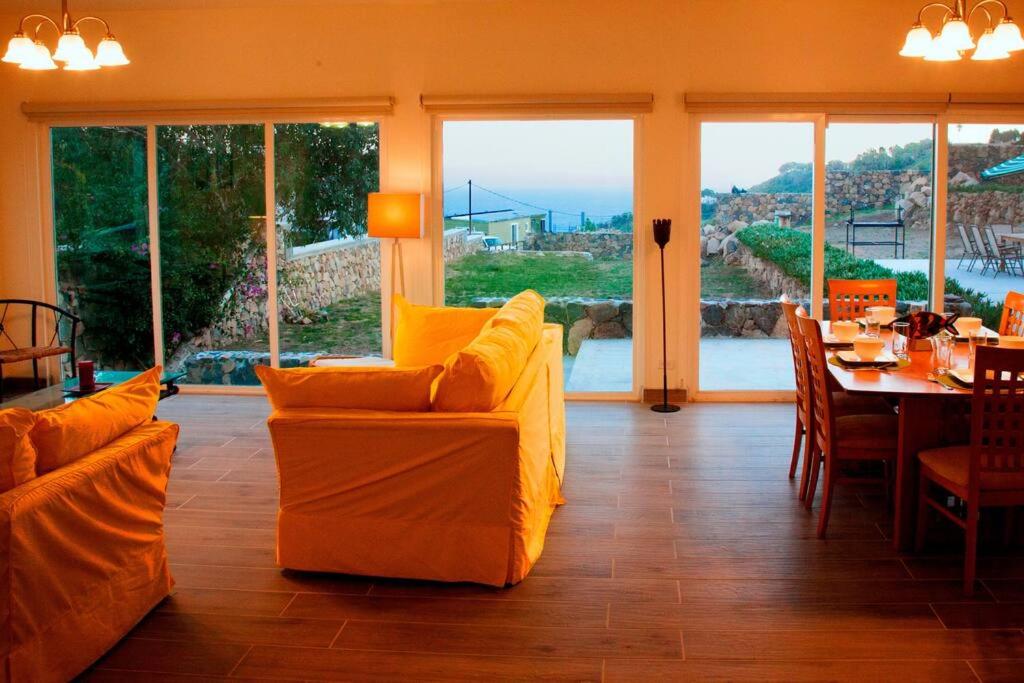 sala de estar con muebles de color naranja, mesa y sillas en Beautiful Ocean views at Quinta la Mexicana! 8 ppl, en Ensenada