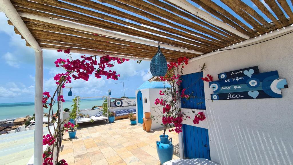 a patio with flowers and a view of the ocean at Pousada Mediterrânea in Pipa