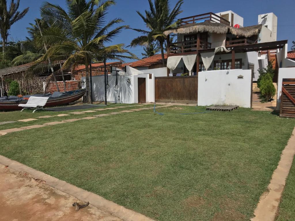 a yard in front of a house with a large yard at Apê Casa da Flor - Maceió, Camocim-CE - Flat Pé na Areia - Vista Mar in Maceio