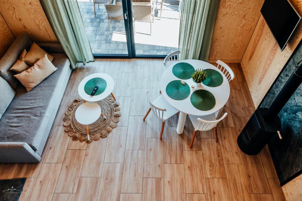 Overhead view of airy living space with sofa, round dining table, wood stove and terrace.