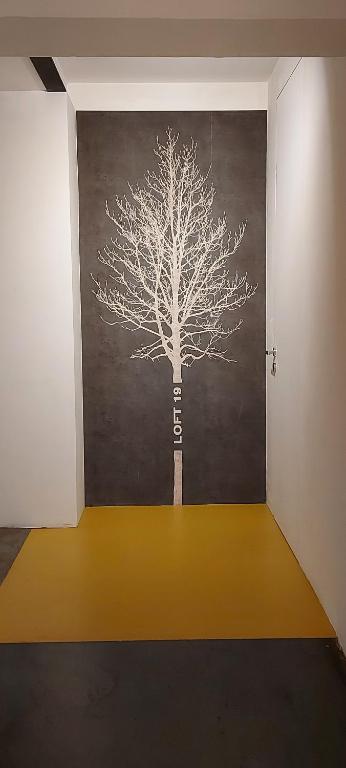 a room with a tree painted on the wall at Loft 19 in Turin