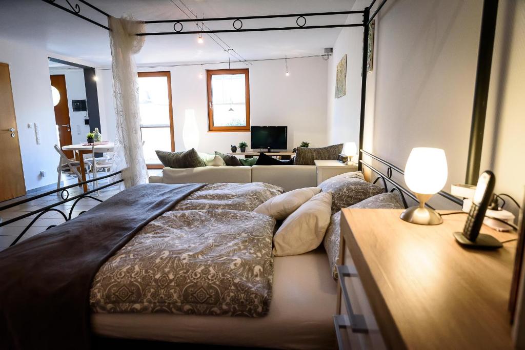 a bedroom with a large bed and a living room at Ferienwohnung Am Backhausgarten in Flonheim