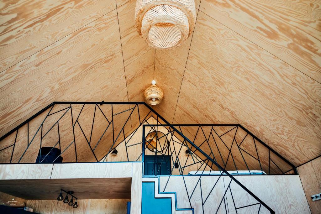 Loft interior showing triangular ceiling, decorative pendant lights and geometric metal railing.