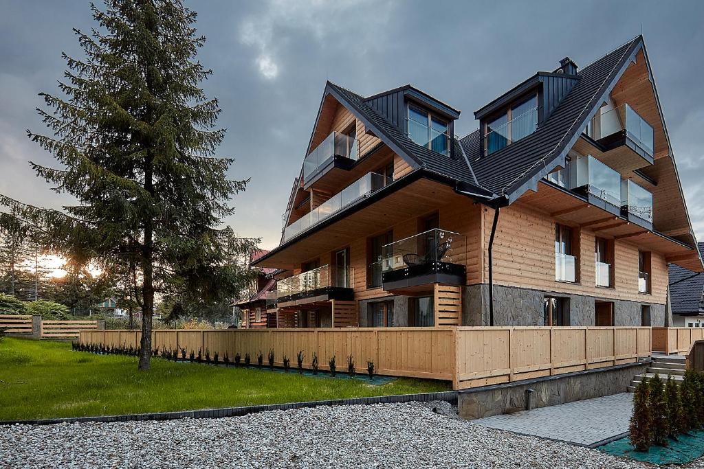 a house with a black roof on top of it at Tatra Square Apartments in Zakopane