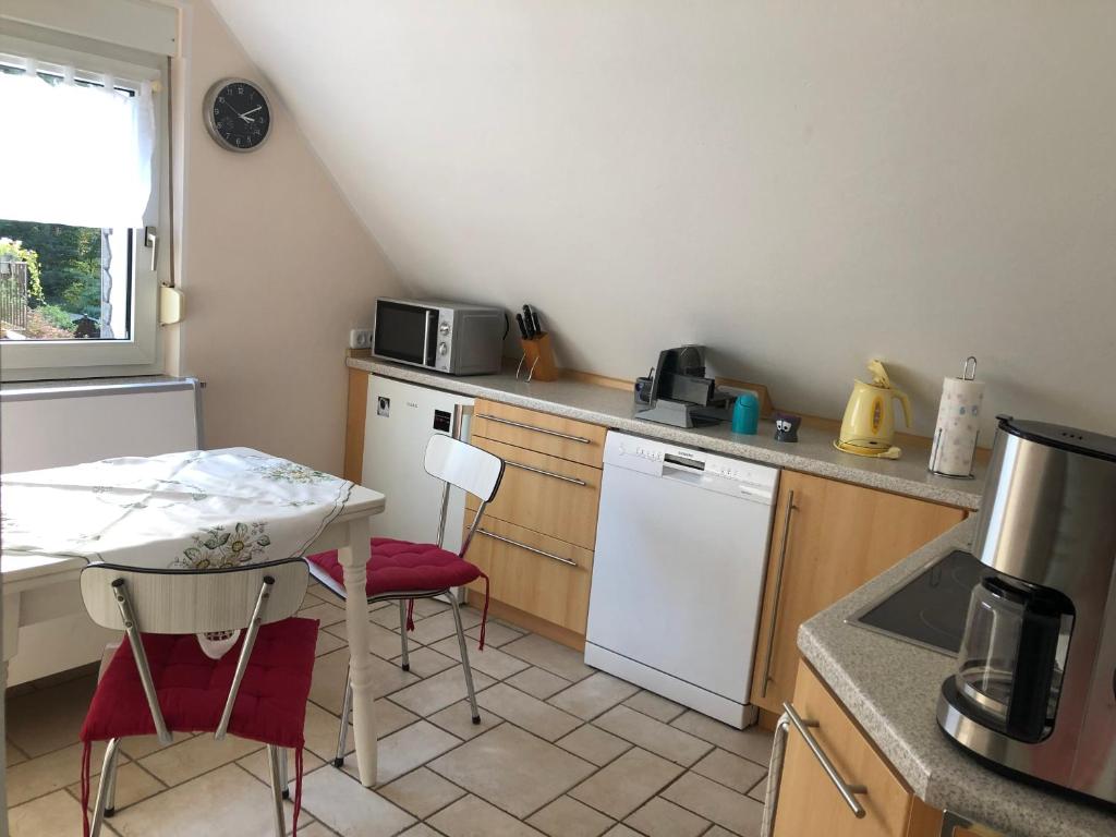 uma cozinha com uma mesa e um frigorífico branco em Constantin em Bochum