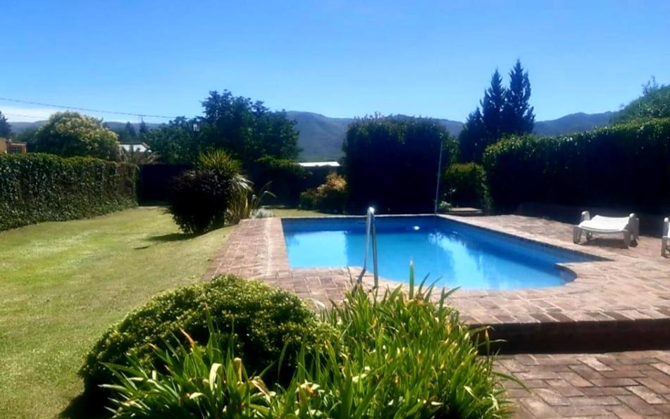 una piscina en un patio con un banco en Casa Cosquin en Cosquín