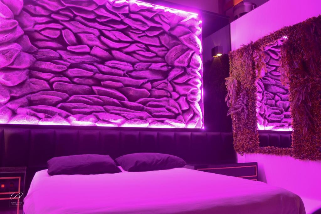 a bedroom with a bed with a rock wall at Amore Mio (Adult Only) in Gramado