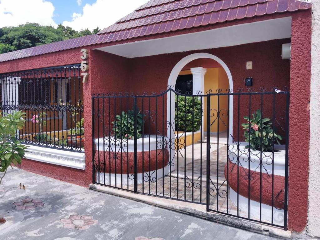 a gate to a house with two potted plants at Casa Balfré in Mérida