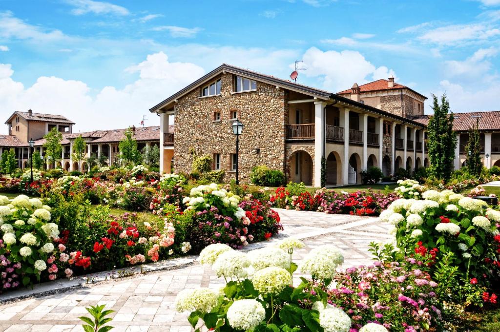 budynek z kwiatami przed nim w obiekcie Garda Residence San Vigilio Golf w mieście Pozzolengo