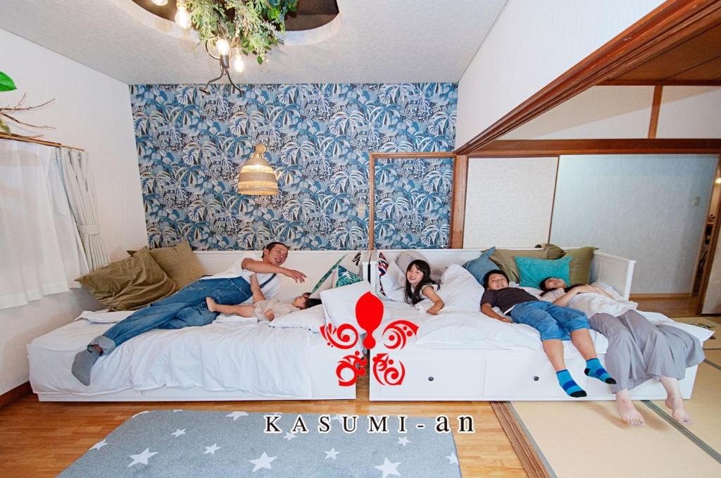 un grupo de personas tumbadas en un sofá en KASUMI-an Hakuzan - Vacation STAY 75321v en Kumamoto