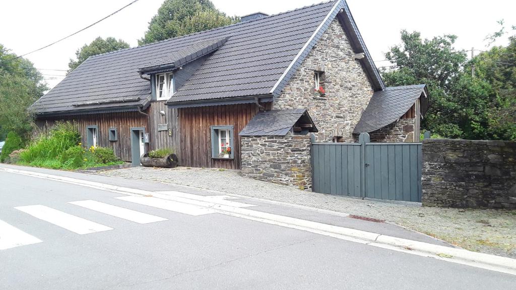 a house with a black roof on a street at Ma baraque de vacances in Butgenbach