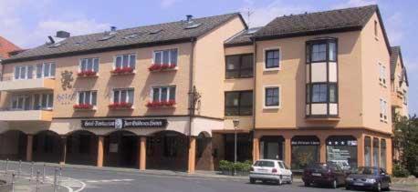een groot gebouw met auto's geparkeerd voor het bij Hotel-Restaurant Zum Goldenen Löwen in Kelkheim