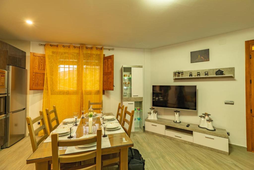 a kitchen and dining room with a table and chairs at CASA ANGEL PAMPANEIRA 3 HAB 2 BAÑOS FACIL ACCESO in Pampaneira