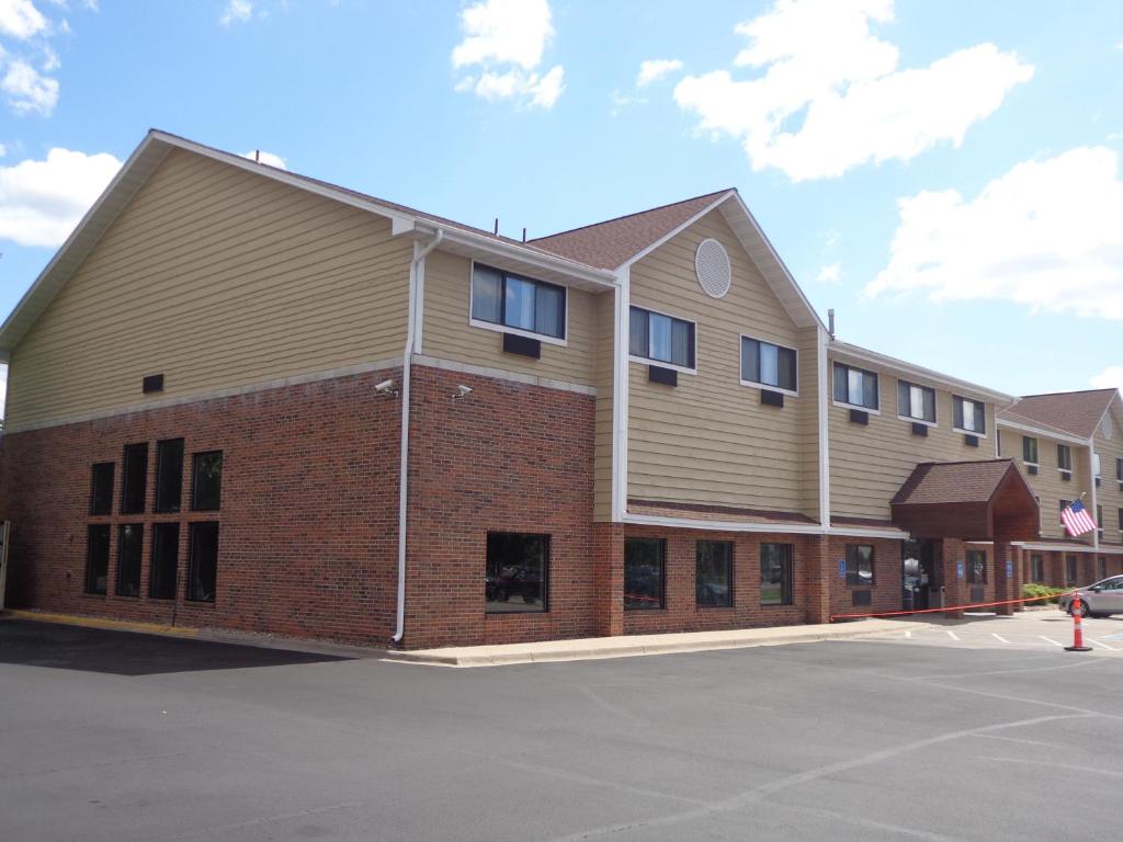a large brick building with windows in a parking lot at Baymont by Wyndham Bloomington MSP Airport in Richfield