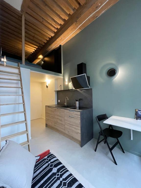 a room with a loft bed and a desk and a kitchen at Le soyeux in Lyon
