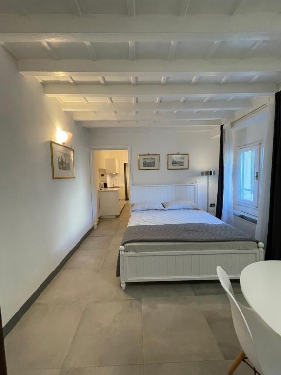 um quarto com uma cama num quarto branco em Renai studio flat em Florença