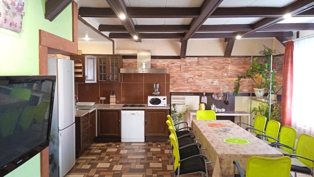 a kitchen with a table and yellow chairs in it at Гостевой дом Territoria Mira in Zhestylevo