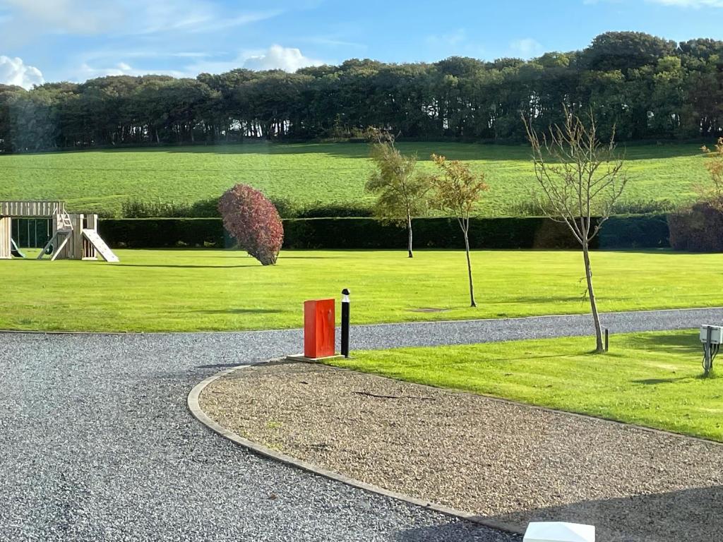 a gravel road with a park with a playground at Happy Days Holiday Home Whithorn2 in Newton Stewart