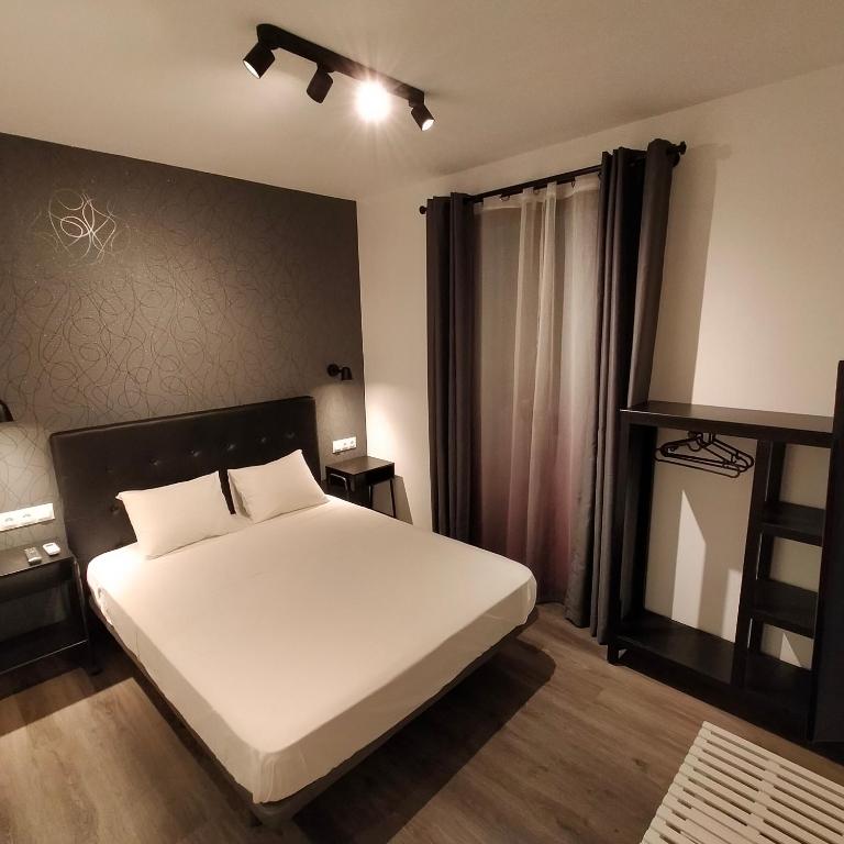 - une chambre avec un lit blanc et une fenêtre dans l'établissement Room Pride, à Madrid