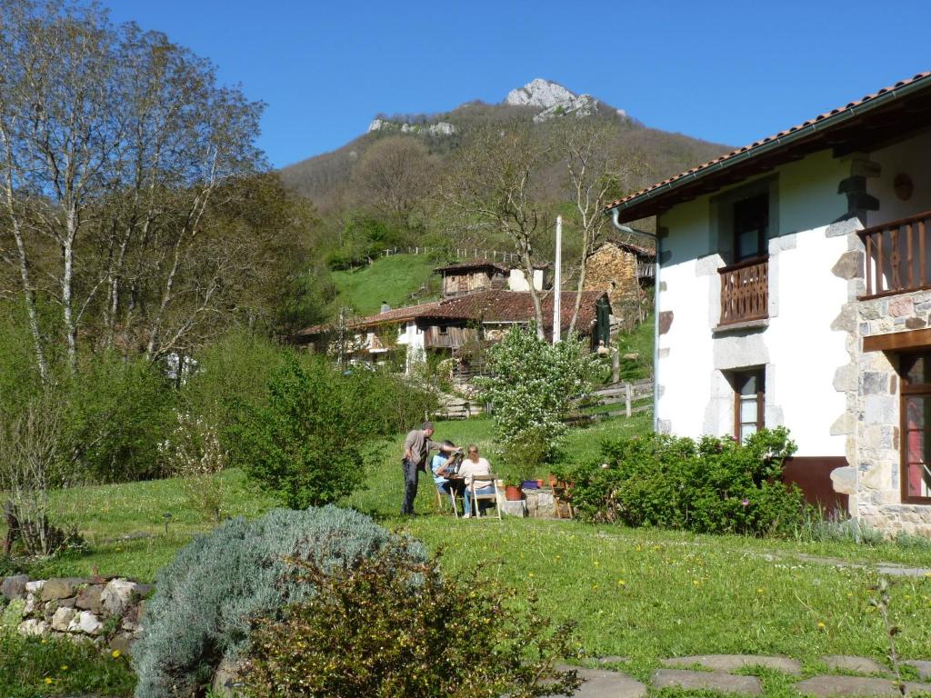 a group of people sitting in the yard of a house at Casa Rural Los Riegos in Caso