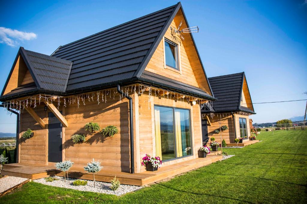 a wooden house with a black roof at WIEJSKI RELAKS in Czarny Dunajec