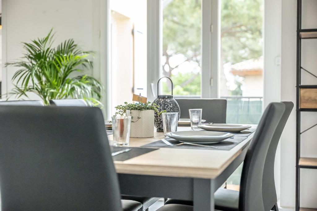 a dining room table with chairs and a table and chairsktop at COSYFAMILY Piscine -WIFI- NEUF-FAMILLE -15MIN PLAGE - TOP PROS SERVICESConciergerie in Pérols