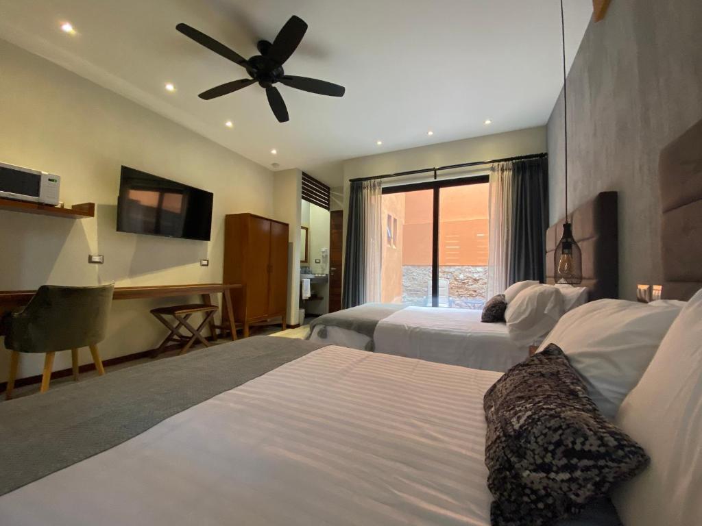 a hotel room with two beds and a ceiling fan at Hotel Arista 1026 in San Luis Potosí